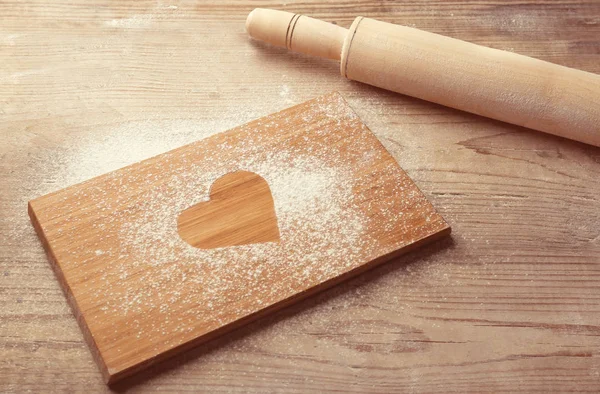Heart on flour and rolling pin — Stock Photo, Image
