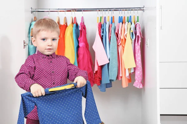 Schattige kleine jongen, het kiezen van kleding in kast — Stockfoto