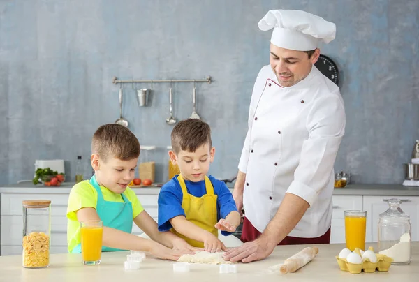 Hombre y dos chicos cocinando juntos en la cocina — Foto de Stock