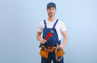 Renk arka plan üzerinde üniformalı yakışıklı genç tesisatçı