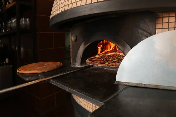 Pizza fırından koyarak — Stok fotoğraf