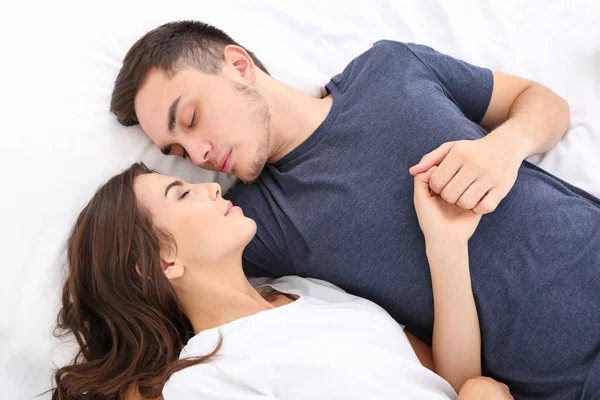 Schönes junges Paar liegt im Bett — Stockfoto