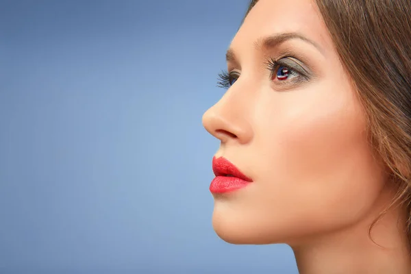 Concepto patriótico. Mujer joven con reflejo de la bandera americana en el ojo sobre fondo azul — Foto de Stock