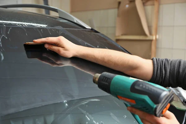 Worker applying tinting foil — Stock Photo, Image