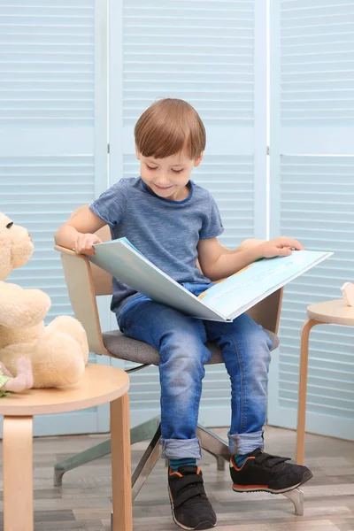 Милий маленький хлопчик читає книгу вдома — стокове фото