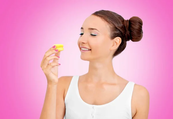 Belle fille avec macaron sur fond de couleur — Photo