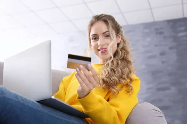 Ung kvinna shopping online med kreditkort och bärbar dator hemma — Stockfoto