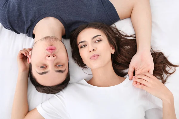 Bonito jovem casal deitado na cama, close-up — Fotografia de Stock