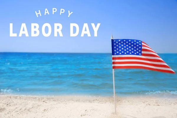 Bandera americana en la playa. Texto FELIZ DÍA DE TRABAJO en el fondo — Foto de Stock