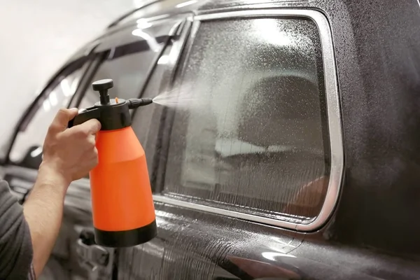 Operaio spruzzando acqua sulla finestra — Foto Stock