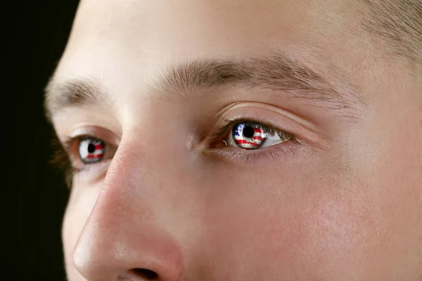 Vatansever kavramı. Genç adam gözleri, closeup Amerikan bayrağı yansıması ile — Stok fotoğraf