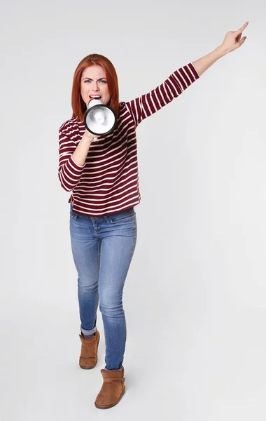 Manifestation jeune femme criant en mégaphone sur fond clair — Photo