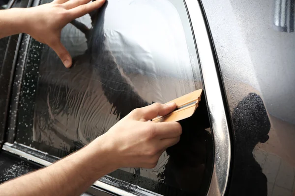 Worker installing foil on car window — Stock Photo, Image