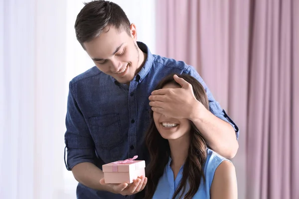 Handsome man giving girlfriend gift — Stock Photo, Image