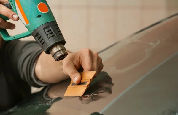 Worker applying tinting foil — Stock Photo, Image