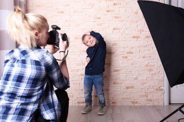 Küçük çocuk fotoğrafçı önünde poz