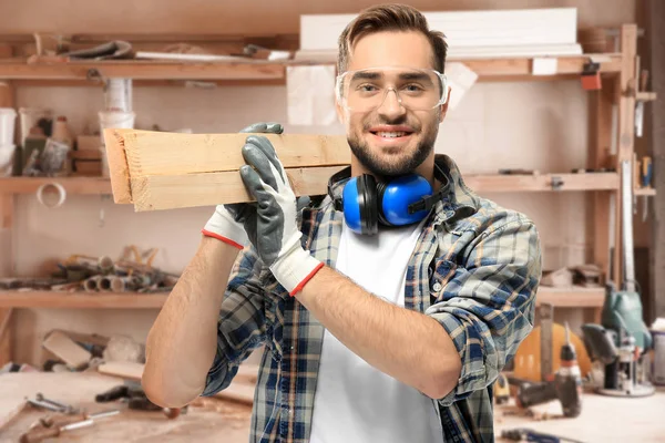 Carpenter holding wooden planks — Stock Photo, Image