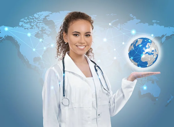 Travel nursing concept. Yong doctor holding globe and world map on background — Stock Photo, Image
