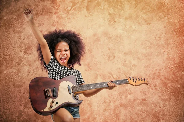 Afro-Amerikaanse meisje gitaarspelen op grunge achtergrond — Stockfoto