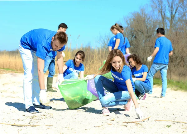 Jeunes bénévoles ramassant des ordures à l'extérieur — Photo