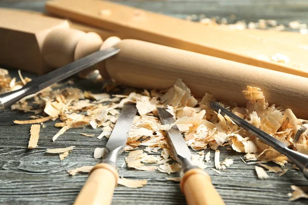 Juego de herramientas, pieza de madera y serrín sobre mesa en taller de carpintería, primer plano — Foto de Stock