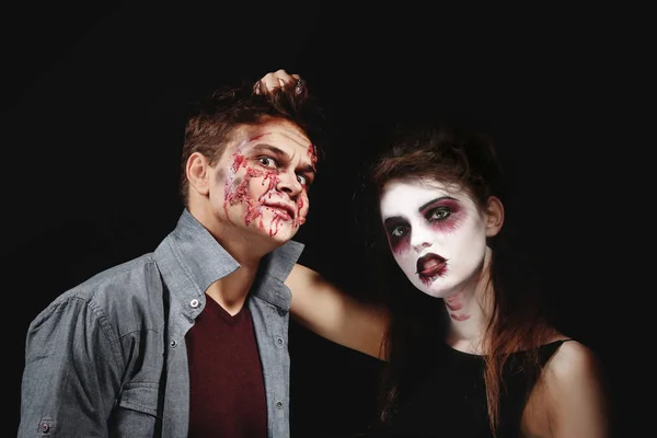 Jovem e mulher com maquiagem Halloween no fundo escuro — Fotografia de Stock
