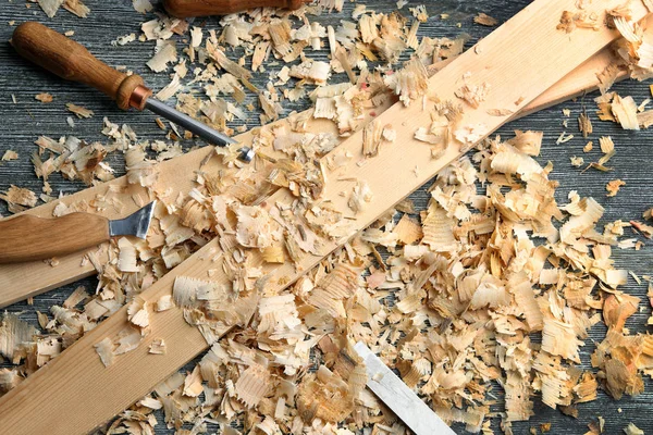 Conjunto de herramientas, tablas de madera y serrín sobre mesa en taller de carpintería —  Fotos de Stock