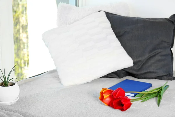 Travesseiros com tulipas e livro — Fotografia de Stock
