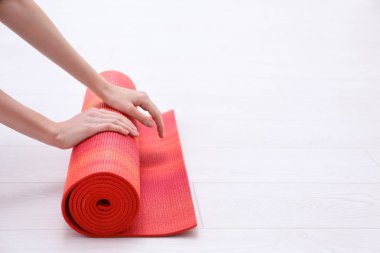 Yoga minderi kıvıran kadın. 