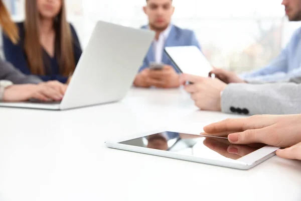 Conceito de trabalho em equipa. Pessoas sentadas à mesa no escritório e usando dispositivos digitais — Fotografia de Stock