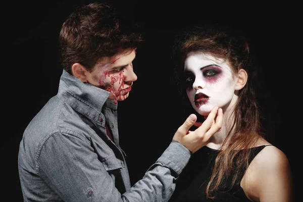 Молодий чоловік і жінка з макіяжем на Хелловін на темному тлі — стокове фото