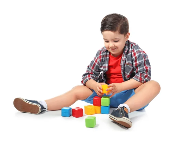 Lindo niño jugando con cubos de colores sobre fondo blanco — Foto de Stock