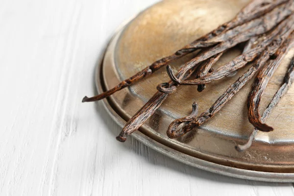 Kurutulmuş vanilya çubukları ve metal plaka — Stok fotoğraf