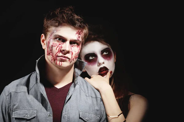 Jovem e mulher com maquiagem Halloween no fundo escuro — Fotografia de Stock