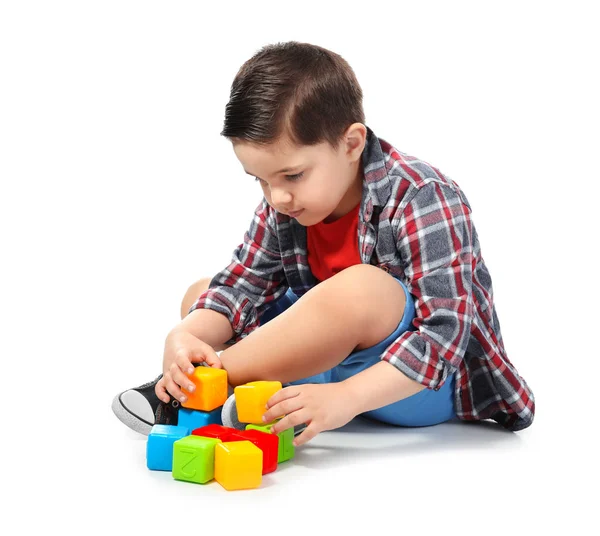 Bonito menino brincando com cubos coloridos no fundo branco — Fotografia de Stock