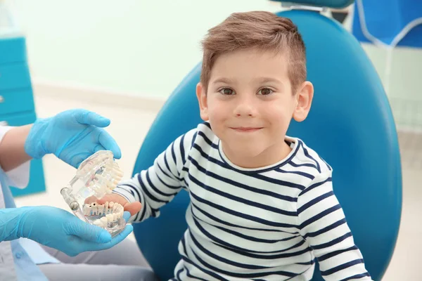 Dentist showing plastic jaw to boy — Stock Photo, Image