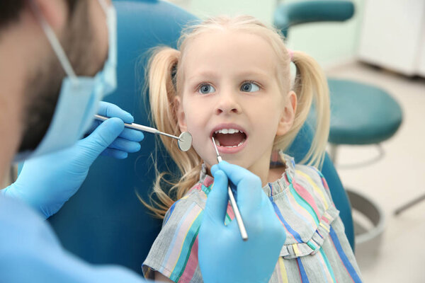 Dentist examining girl's teeth