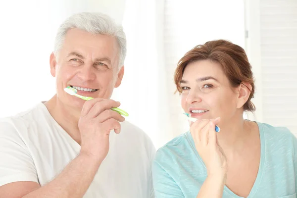 Pareja mayor limpiando dientes en casa — Foto de Stock