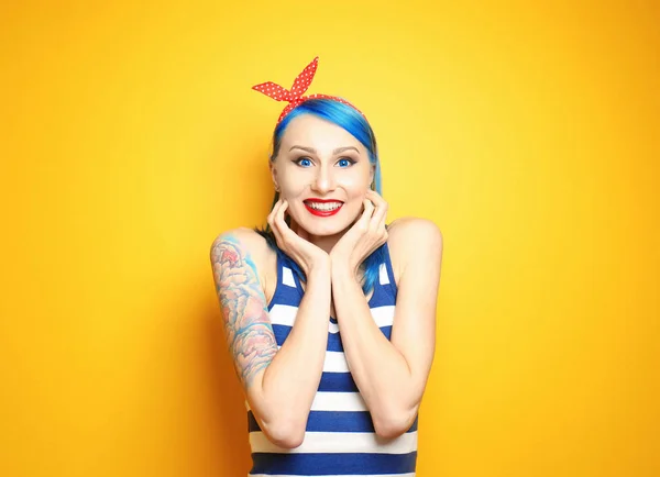 Όμορφη νεαρή γυναίκα με το κομψό χρώμα μαλλιών και τατουάζ σε κίτρινο φόντο — Φωτογραφία Αρχείου
