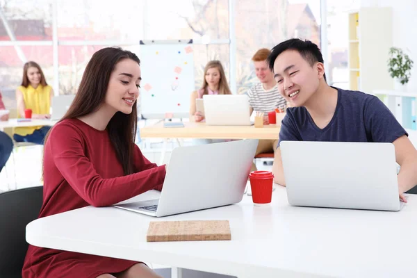 Junge Leute arbeiten im Büro mit Laptops — Stockfoto