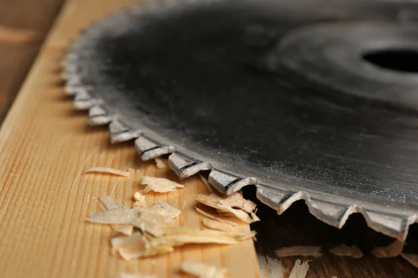 Disco de sierra circular y tablero de madera en taller de carpintería, primer plano — Foto de Stock