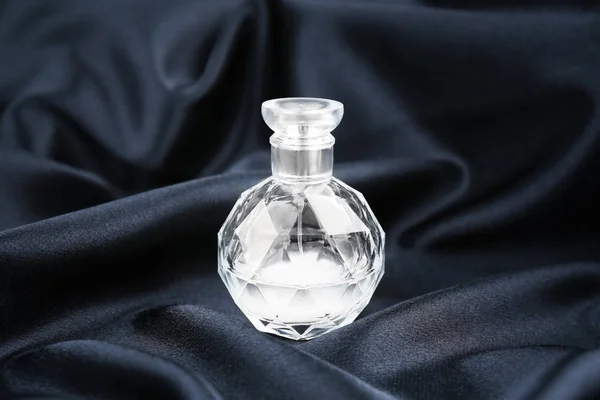 Бутылка духов на ткани — стоковое фото