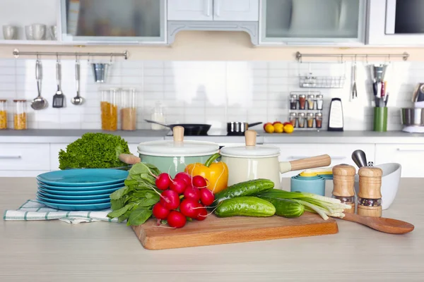 Свіжі овочі та посуд для уроків приготування їжі на дерев'яному столі — стокове фото