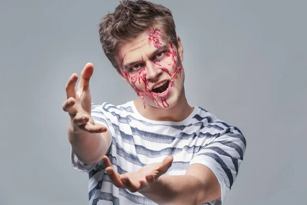 Młody człowiek z Halloween makijaż na szarym tle — Zdjęcie stockowe