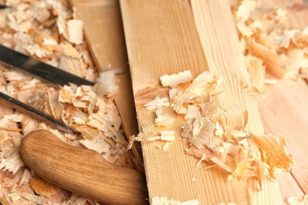 Herramientas de carpintero, tablas y serrín sobre mesa de madera en taller, primer plano — Foto de Stock