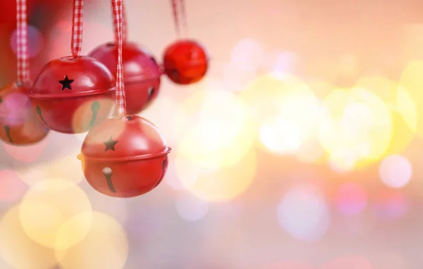 Jingle bells on blurred lights background, closeup. Concept of Christmas music and songs — Stock Photo, Image