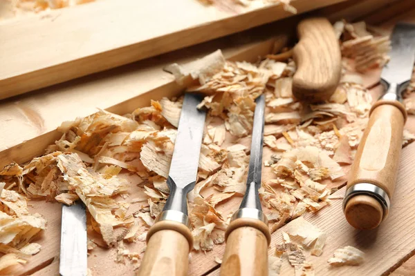 Herramientas de carpintero, tablas y serrín sobre mesa de madera en taller, primer plano — Foto de Stock