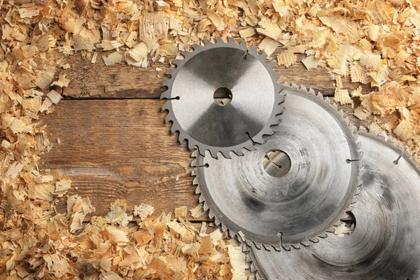 Composição com discos de serra circular de carpinteiro e pó de serra em fundo de madeira — Fotografia de Stock