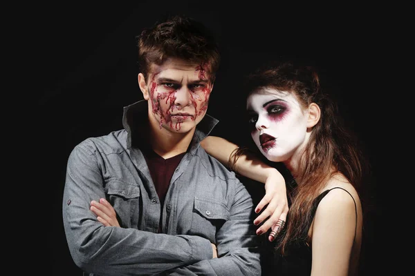 Genç adam ve kadın koyu arka plan üzerinde Halloween makyaj ile — Stok fotoğraf