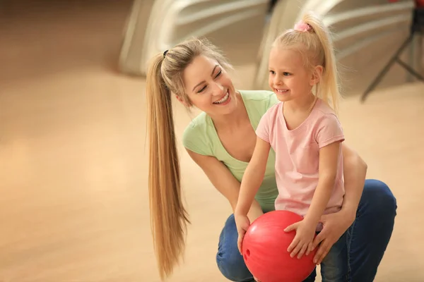 Wanita muda dan putrinya bersenang-senang di klub bowling — Stok Foto
